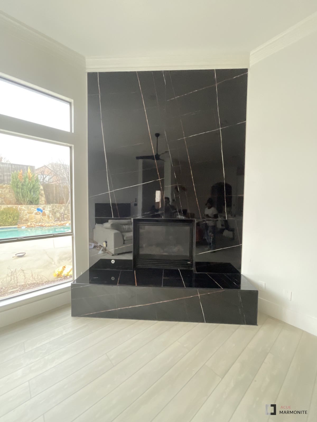 Floor-to-ceiling fireplace wall installed by Acue Marmonite